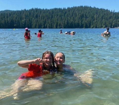 two smiling kids in the water at the beach