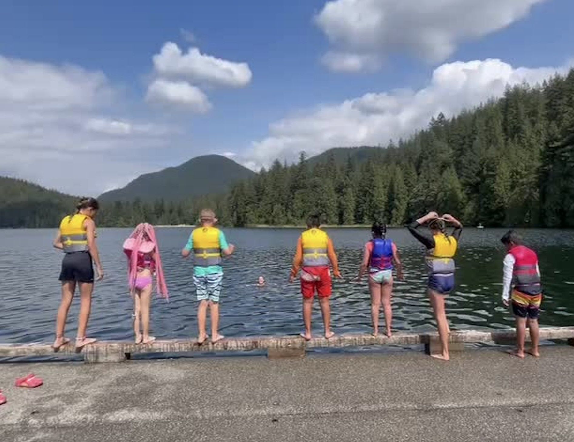 kids in lifejackets preparing to dock jump